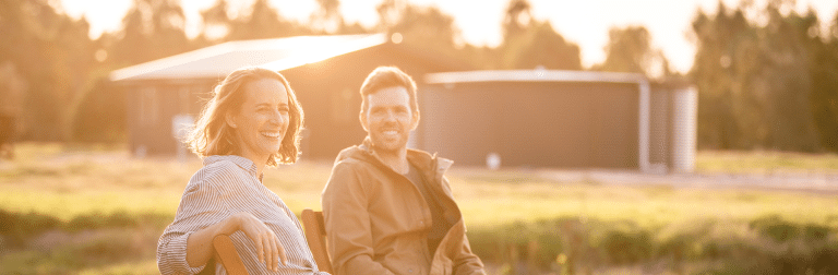 A couple sitting in front of their modular country home